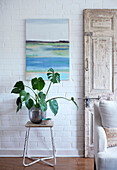 Houseplant on stool with artwork in whitewashed room Tunbridge Wells home, Kent, UK