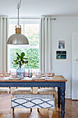 Cut leaves and crockery on wooden dining table at window in Tunbridge Wells home, Kent, UK
