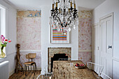Chandelier above wooden table in partially decorated Camber cottage, East Sussex, UK