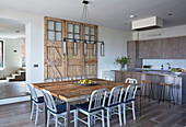 Open plan kitchen and dining room with salvaged barn door in Rye conversion, East Sussex