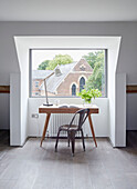 Desk and chair at picture window in Rye barn conversion, East Sussex