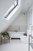 Skylight window and freestanding bath in attic of Rye barn conversion, East Sussex