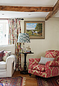 Contrasting fabrics on armchair and curtains in Berkshire cottage, England, UK