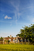 Feld und Zaun umgeben eine umgebaute Kirche in Sandford St Martin, Oxfordshire, UK