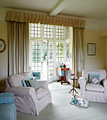 Pair of upholstered armchairs in leaded bay window of Syresham home, Northamptonshire, UK
