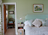Contrasting wallpaper and fabric patterns in bedroom of Northumberland farmhouse, UK