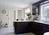 Wall mounted radiator in black fitted kitchen in North Yorkshire home, UK