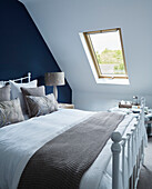 Blue and beige attic bedroom in detached North Yorkshire home, UK