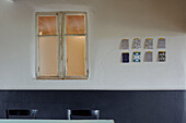 Postkarten an der Wand neben dem Fenster in einem bretonischen Landhaus in Frankreich
