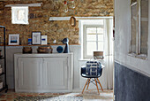 Blue and white interior of Brittany cottage with exposed stone wall France
