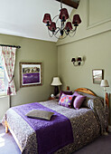 Purple and green bedroom in Cotswolds cottage, UK