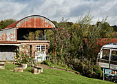 Garden with Majestic bus beside Dutch barn near Hay-on-Wye, Wales, UK