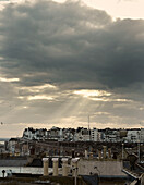 Sunlight through clouds above rooftops in Ramsgate harbour Kent, UK