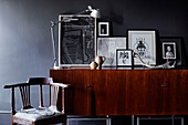 Desk lamp and framed prints on wooden sideboard with antique chair in Ramsgate home Kent, UK