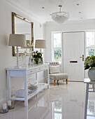 Pair of lamps and large mirror in white entrance hall of York home, UK
