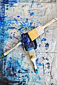 Drei Pinsel und blaue Farbe auf Staubtuch in einem Atelier in Sligo, Irland