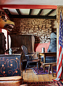 Animal heads and US flag with exposed stone wall and antiques in Devon home, UK