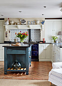 Blaugrüne Kücheninsel und Backsteinboden in einer Küche in Devon, UK