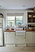 Butler sink and plate rack at kitchen window in West Sussex home, UK