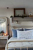 Floral pillow on metal framed bed in West Sussex home, UK