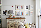 Framed prints with lamp on sideboard in Oxfordshire living room, UK