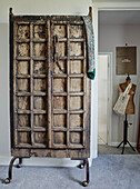 Salvaged screen door on casters with dressmakers dummy in North Yorkshire farmhouse, UK