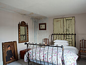 Vergoldeter Spiegel und Kunstwerk mit Metallrahmenbett und alten Türen in einem Bauernhaus in North Yorkshire, UK