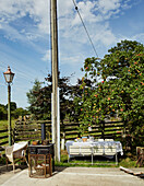 Herd und Feuerschutz mit Tischen und Stühlen um einen Telegraphenmast in North Yorkshire, UK