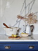 Dried flowers in coffee pot with mortar and pestle and cut lemons in North Yorkshire farmhouse kitchen, UK