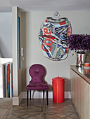 Purple chair and pop art with red dustbin in London apartment, UK