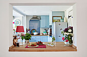 Schnittblumen und Basilikum auf hölzerner Arbeitsplatte in hellblauer Landhausküche, UK