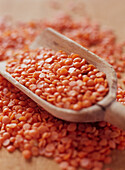 Raw red lentils with wooden scoop