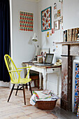 Bemalter Stuhl am Schreibtisch mit Kunstwerken in einem Einfamilienhaus in Colchester, Essex, England, UK