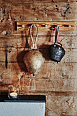 Cowbells hanging on a timber wall in a Wooden cabin situated in the mountains of Sirdal, Norway