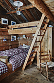 Etagenbetten und karierte Bettwäsche in einem Kinderzimmer in einer Holzhütte in den Bergen von Sirdal, Norwegen