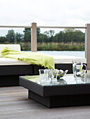 Garden furniture on a decked terrace overlooking a lake