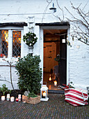 Beleuchtete Kerzen und Laternen an offener Tür von einem Cottage in Herefordshire, England, UK