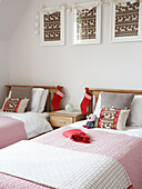 Twin beds with Christmas stockings and co-ordinating reindeer artwork and cushions, in Polish home
