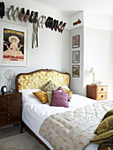 Shoe collection above antique bed in in Winchester home, Hampshire, UK