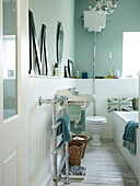 Pastel green and white bathroom with wall mounted cistern and oversized letter M in Winchester home, Hampshire, UK