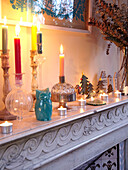 Lit candles on marble fireplace in family home, France