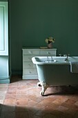 Bathtub and dresser in pastel green bathroom