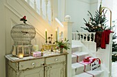 Entrance hall and staircase with Christmas tree presents and burning candles
