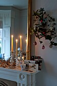 Weihnachtskarten und Kerzen auf dem Kaminsims