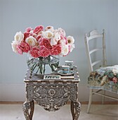 Vase mit Blumen auf Nachttisch
