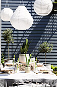 Solarlaternen über einem Tisch auf einer Terrasse mit sonnenbeschienener Holzverkleidung Colchester Essex UK