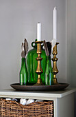 Vintage glass bottles with feathers and brass candlesticks in Colchester home, Essex, UK