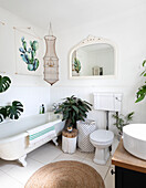 Houseplants and mirror with fishing net and jute rug in botanic Colchester bathroom Essex UK