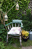 Old wooden chair with rusty metal lanterns in Brighton garden East Sussex UK