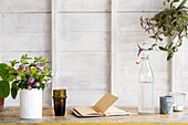 Schnittblumen und Notizbuch auf Tischplatte in Atelierschuppen Guildford Surrey UK